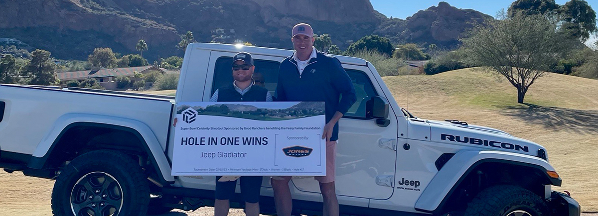 Male golfers posing for picture holding up a hole in one contest sign